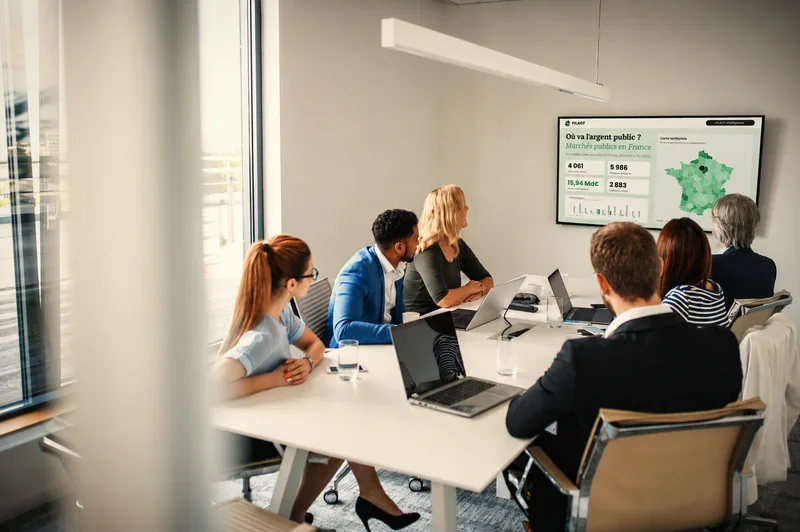 Une équipe réunie autour d'une table examine les données de PILAOT Intelligence.